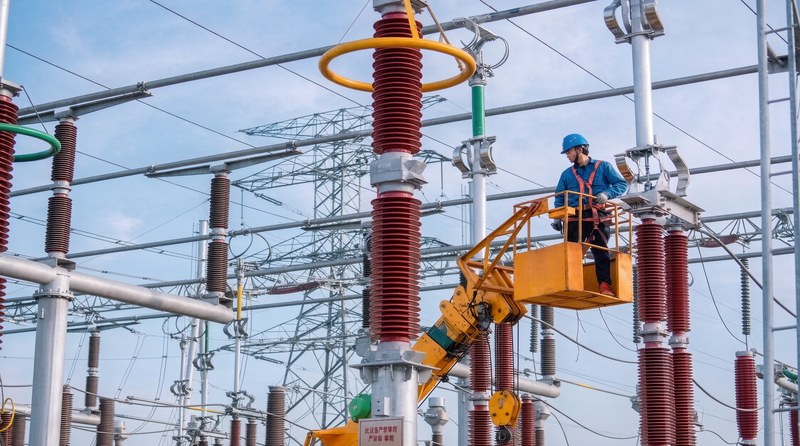 Photograph of a lattice transmission tower with insulator strings and conductors