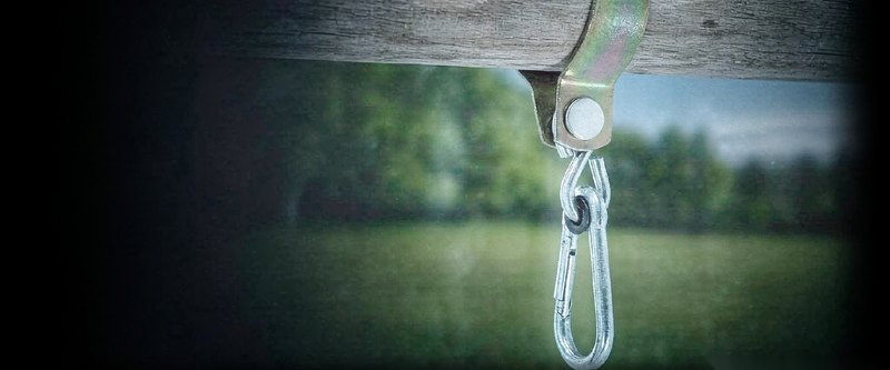 Galvanized swing hook with eye strap hanging on a timber post