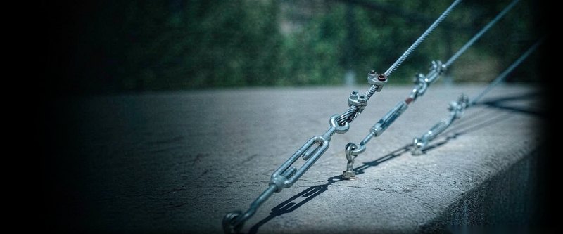 Steel wire rope tensioned with forged turnbuckles on a concrete surface